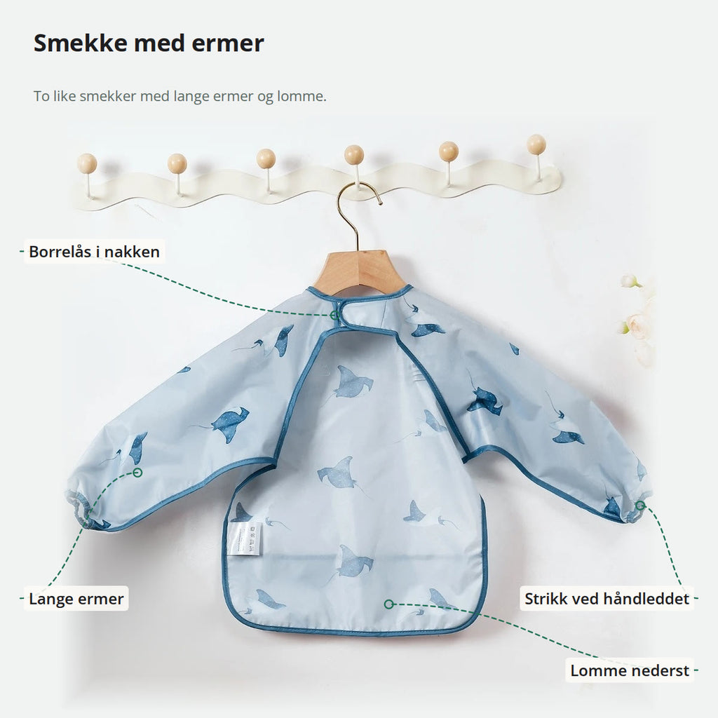 Smekke med ermer merket med borrelås i nakken, lange ermer, strikk ved håndleddet og lomme nederst