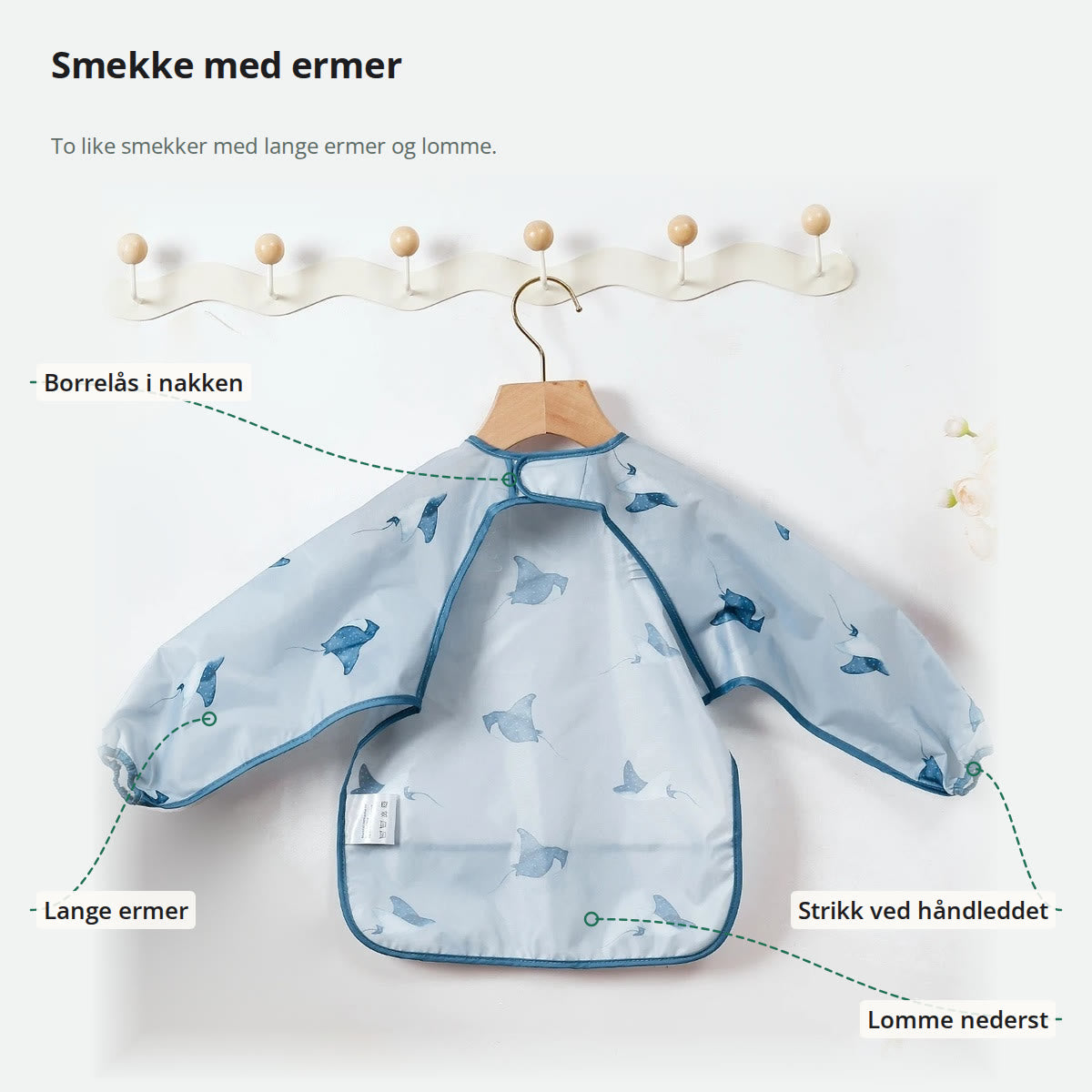 Smekke med ermer merket med borrelås i nakken, lange ermer, strikk ved håndleddet og lomme nederst