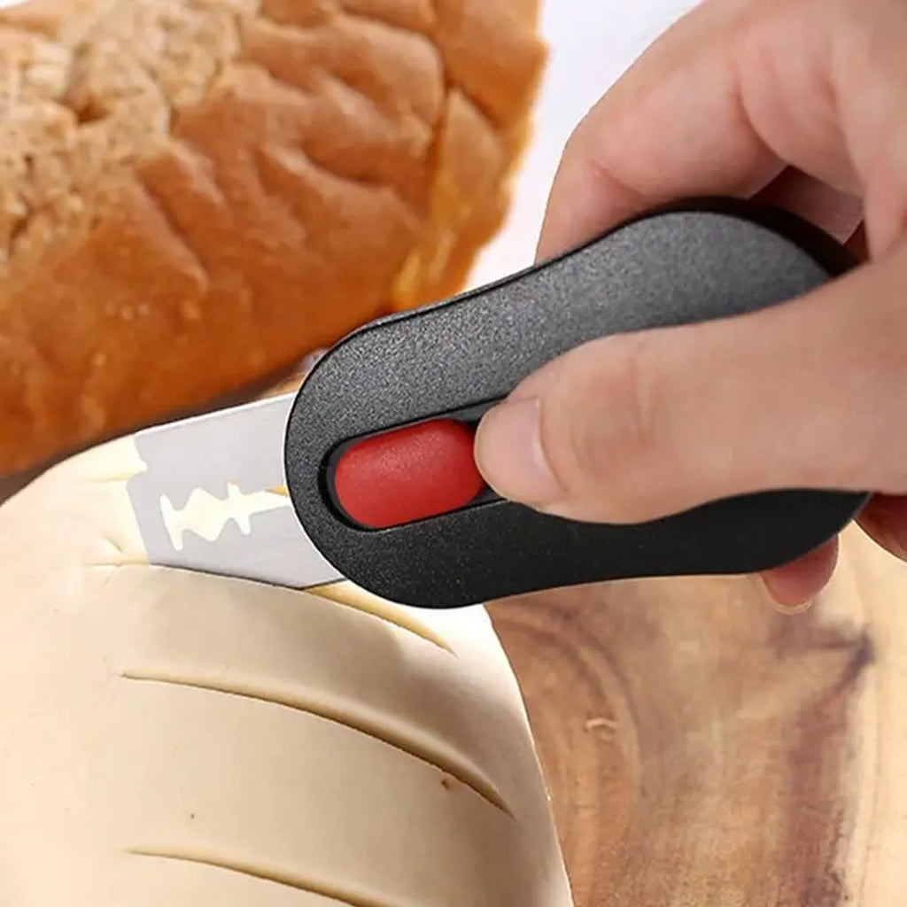 Hånd som lager et snitt i en brøddeig med snittekniven