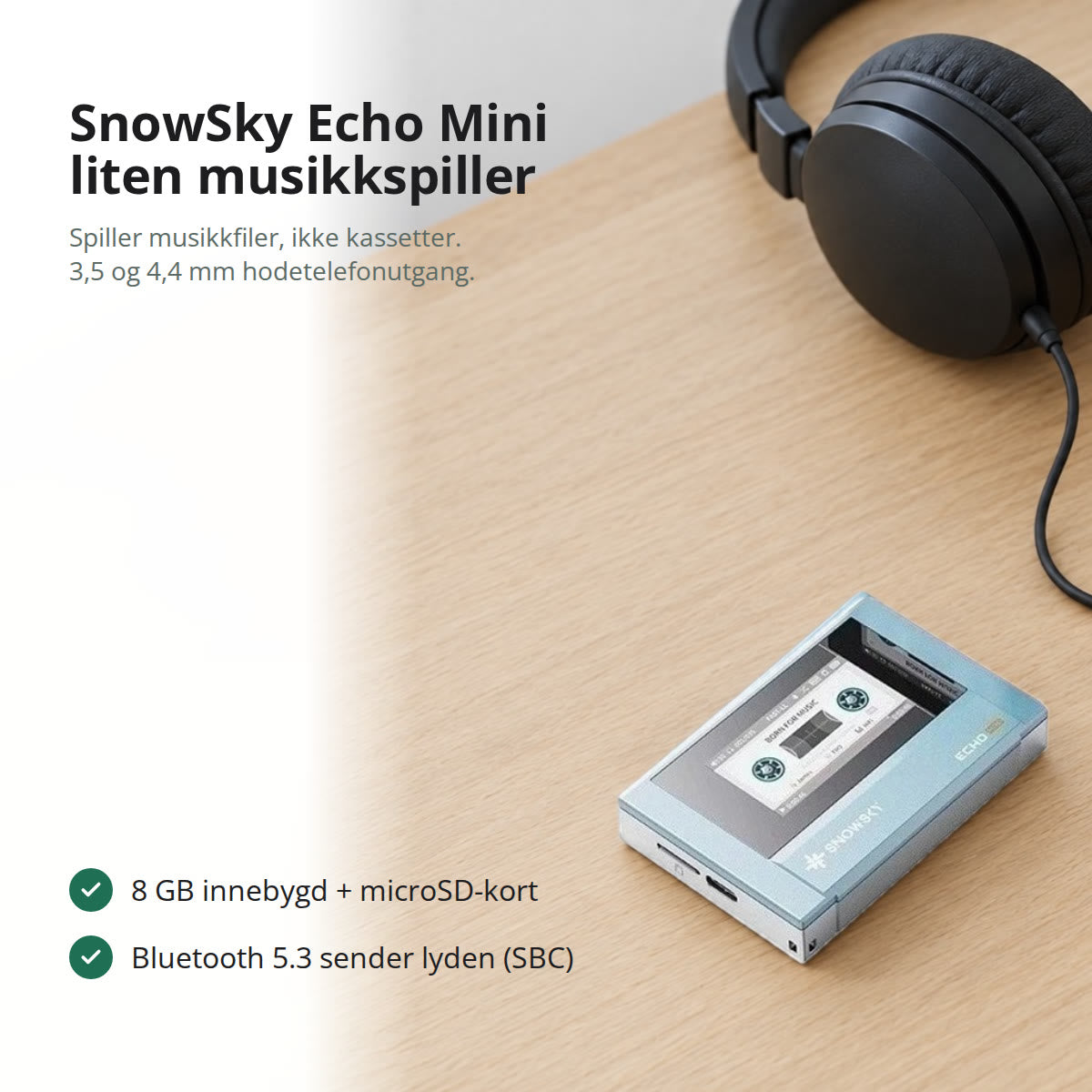 Himmelblå SnowSky Echo Mini liggende på et lyst eikeskrivebord, med svarte hodetelefoner med ledning i bakgrunnen