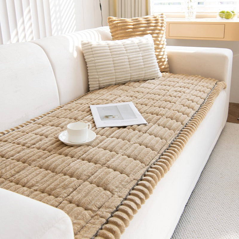 Kosla-trekk i beige på setet til en hvit sofa