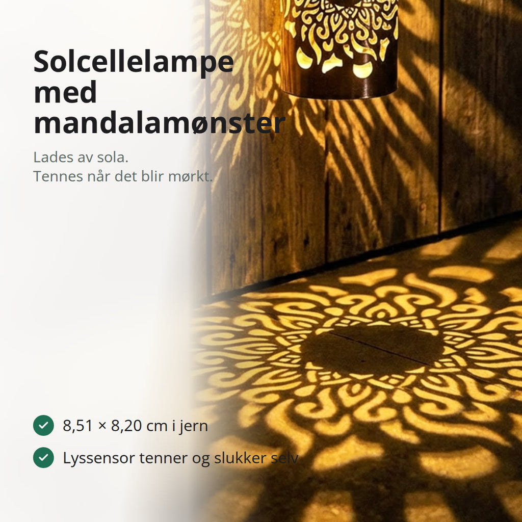 Solcellelampe i sort jern som kaster et mandalamønster i varmt gult lys på en trevegg