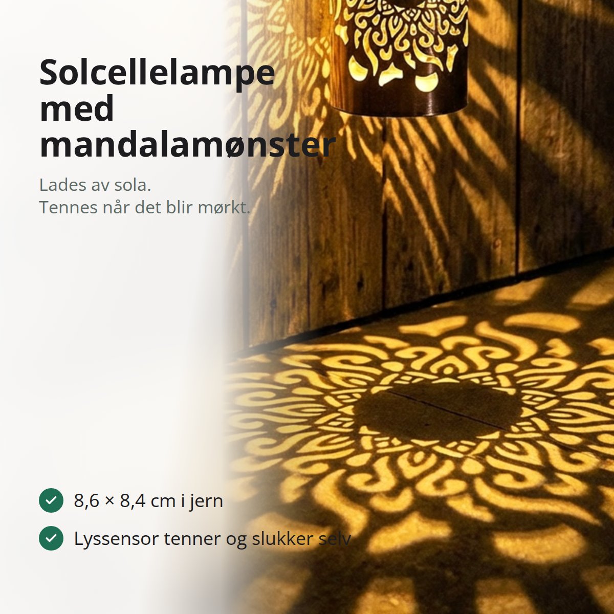 Solcellelampe i sort jern som kaster et mandalamønster i varmt gult lys på en trevegg