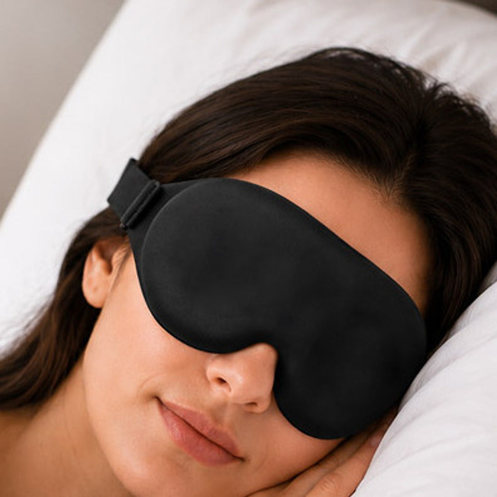 Kvinne som sover med den svarte 3D-sovemasken, stroppen går over øret