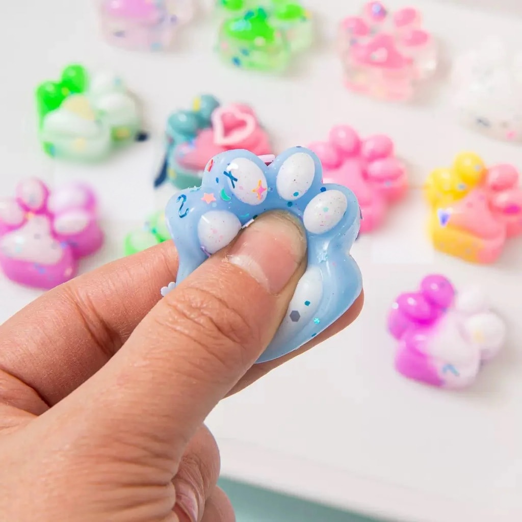 En hånd klemmer en blå squishy-kattepote