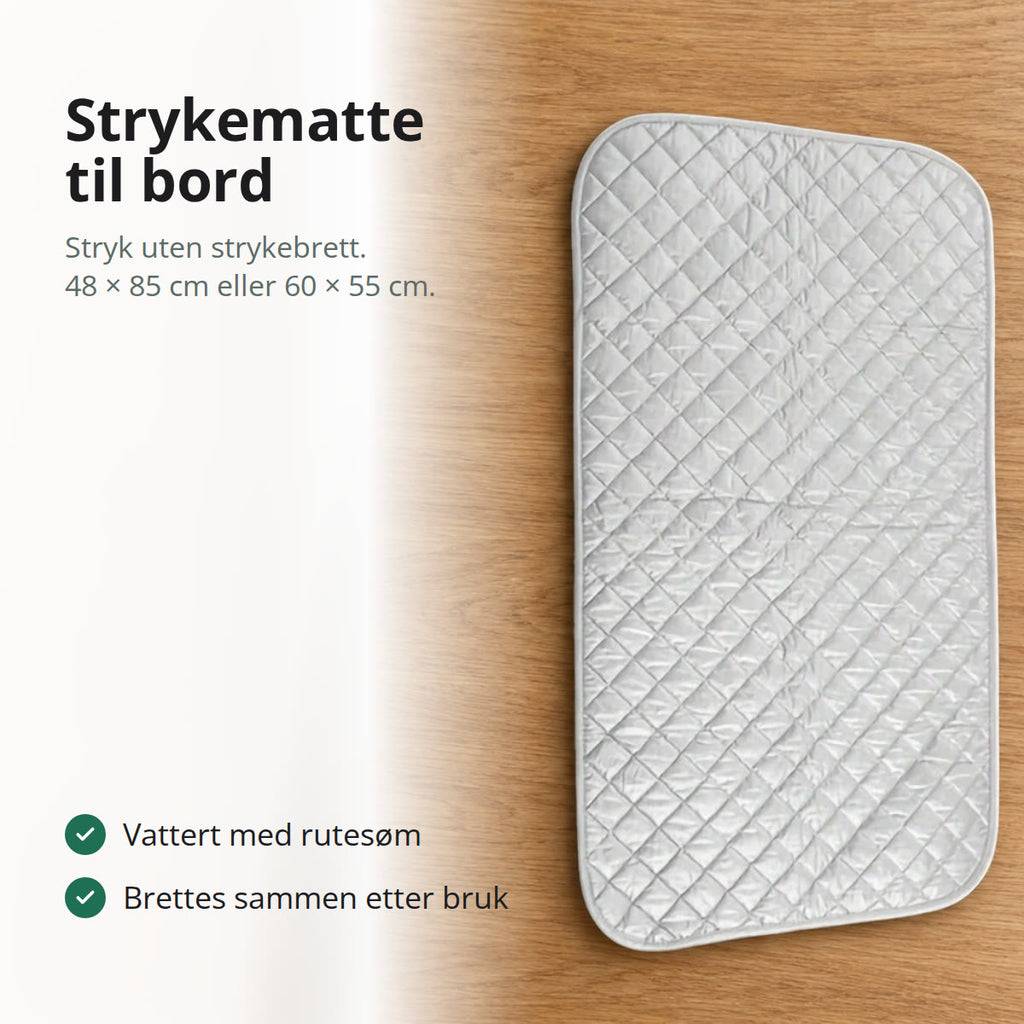 Sølvgrå, vattert strykematte med rutesøm og avrundede hjørner, lagt flatt på et bord i eik