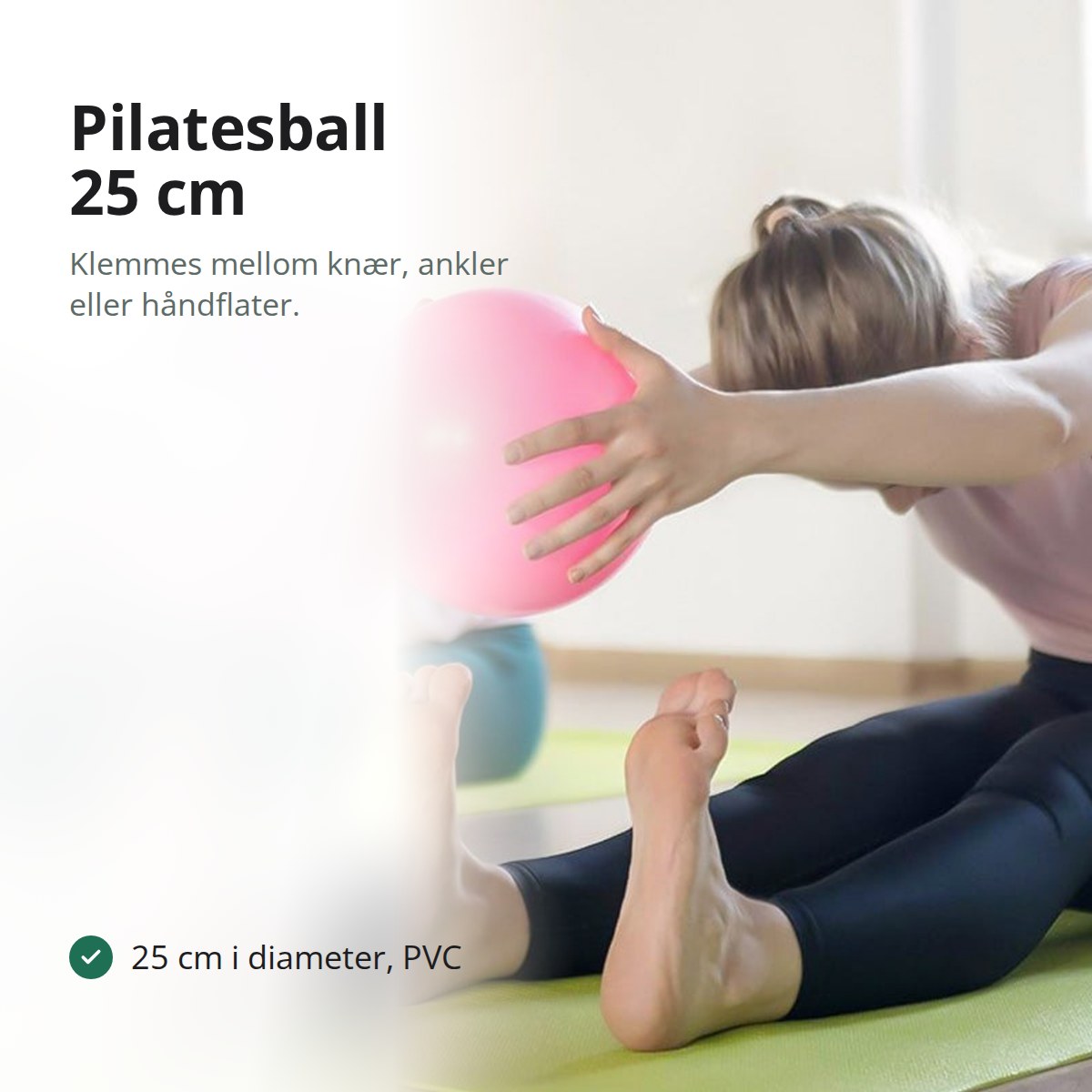 Rosa pilatesball på 25 cm holdt med begge hender under en øvelse på treningsmatte