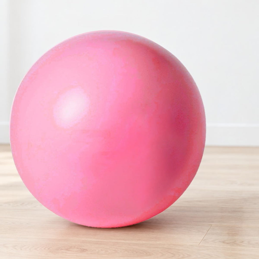 Rosa pilatesball på et lyst eikegulv