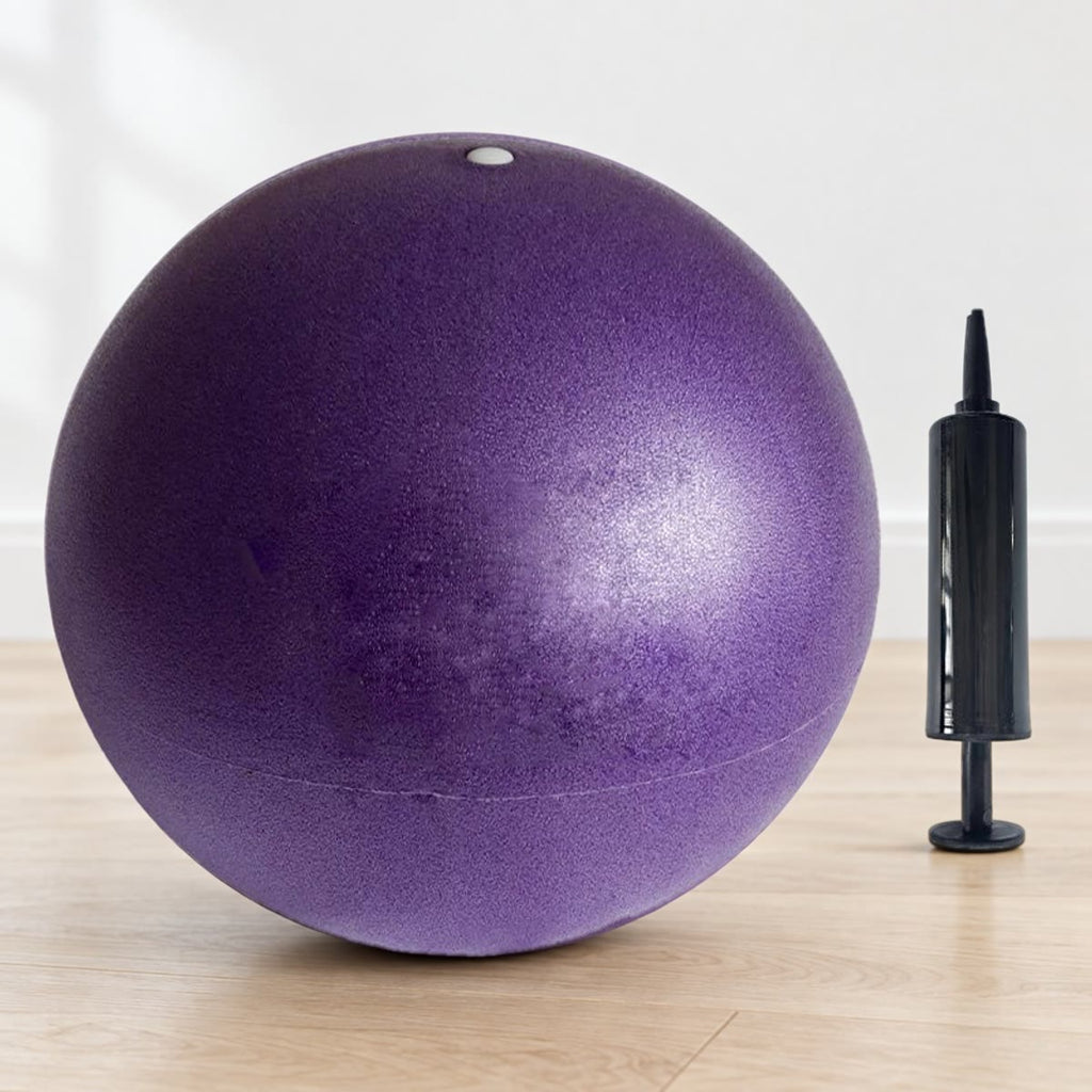 Lilla pilatesball med ventil i toppen og pumpe, på lyst gulv