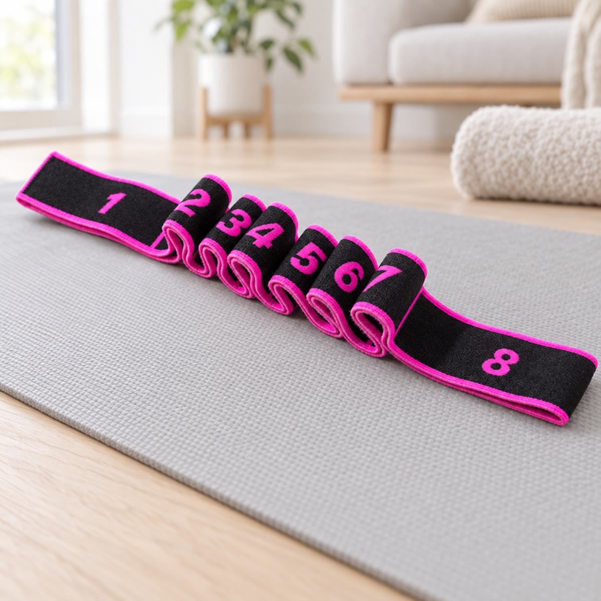 Treningsstrikk med magenta kant og tall på løkkene, liggende på en yogamatte