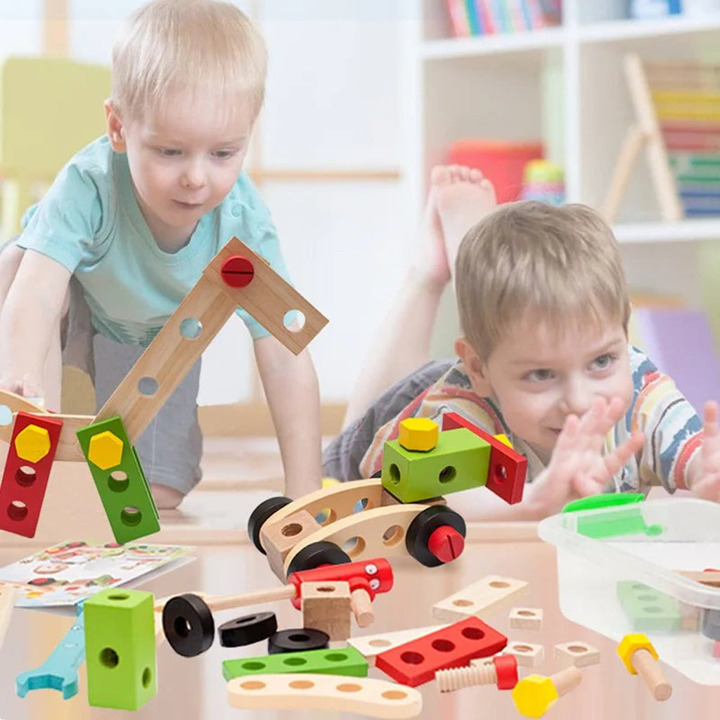 To barn som bygger med treplater, skruer og hjul på gulvet