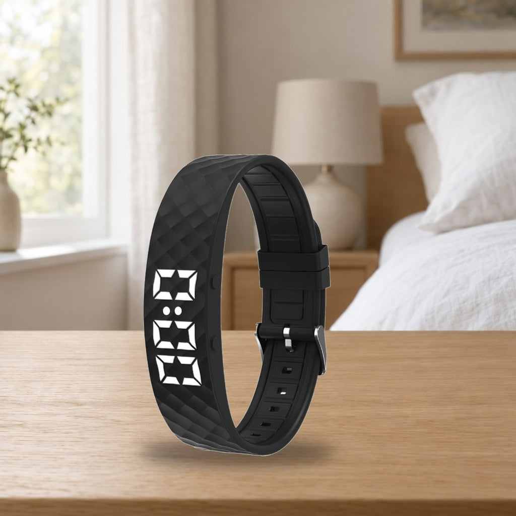 Stillvekk vekkerarmbånd med LED-skjerm stående på et nattbord i et lyst soverom