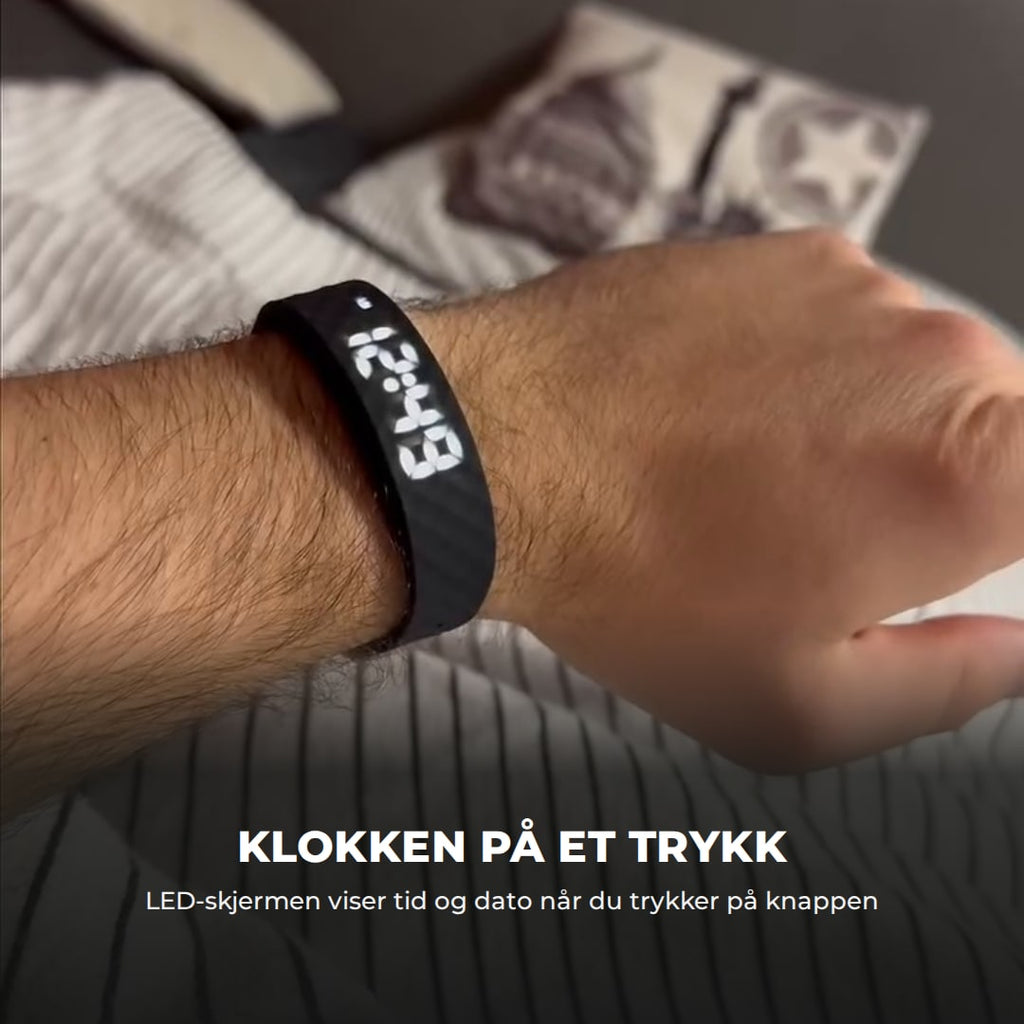 Armbåndet på et håndledd med klokkeslettet tent på LED-skjermen