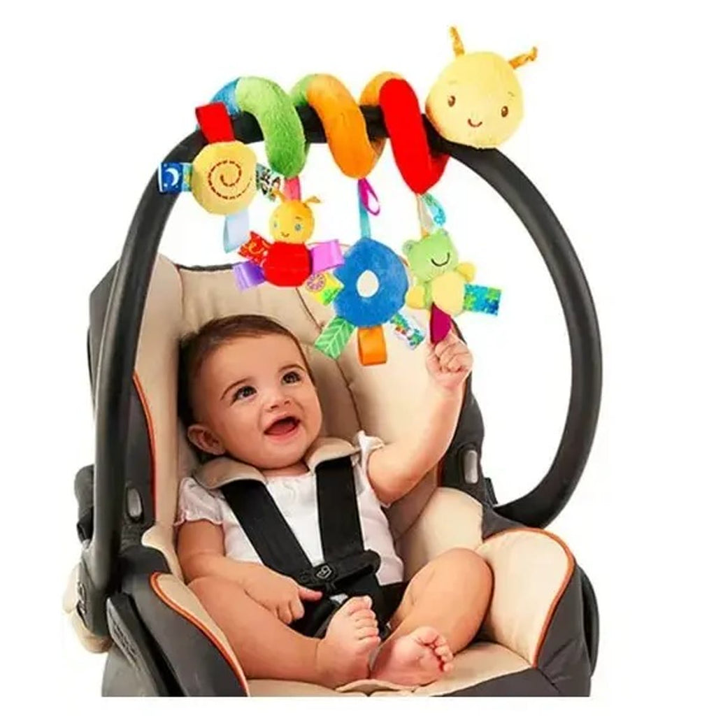 Vognleke tvinnet rundt håndtaket på en bilstol med en smilende baby